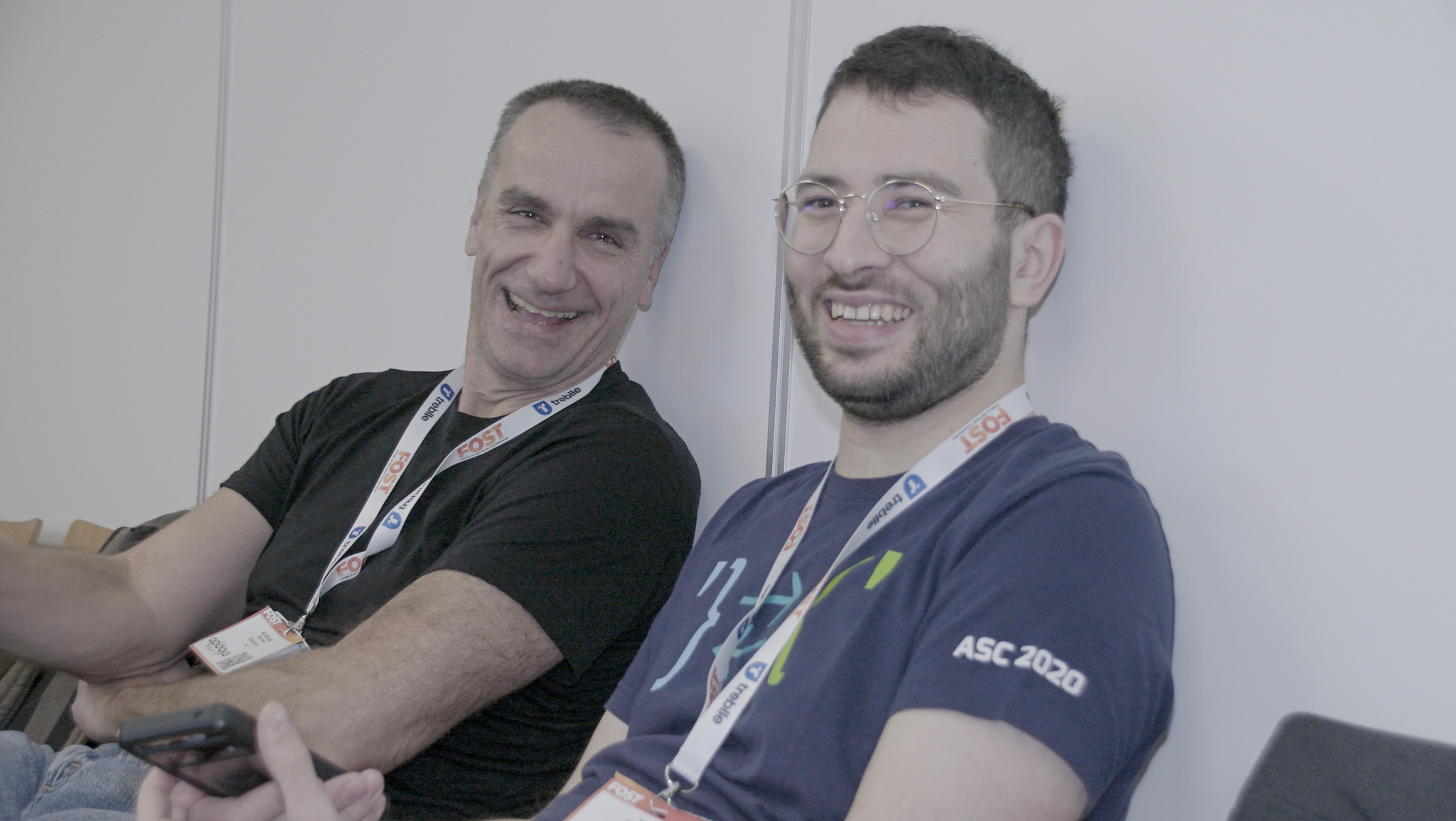 Two people looking at the camaera, seated and smiling. From left to right, their names are Andreas Eberhart, Ege Korkan.